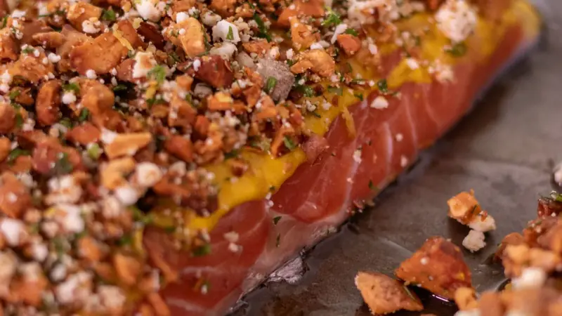 Herb crusted baked salmon fillet resting on parchment paper after cooking