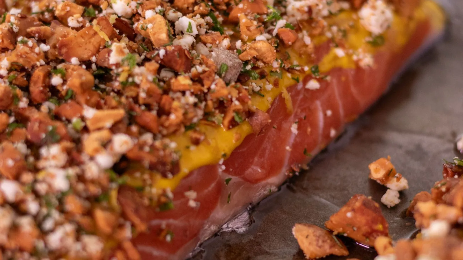 Herb crusted baked salmon fillet resting on parchment paper after cooking