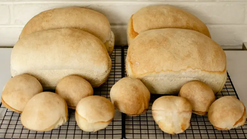 A freshly baked loaf of bread made with bread flour cooling on a wire rack