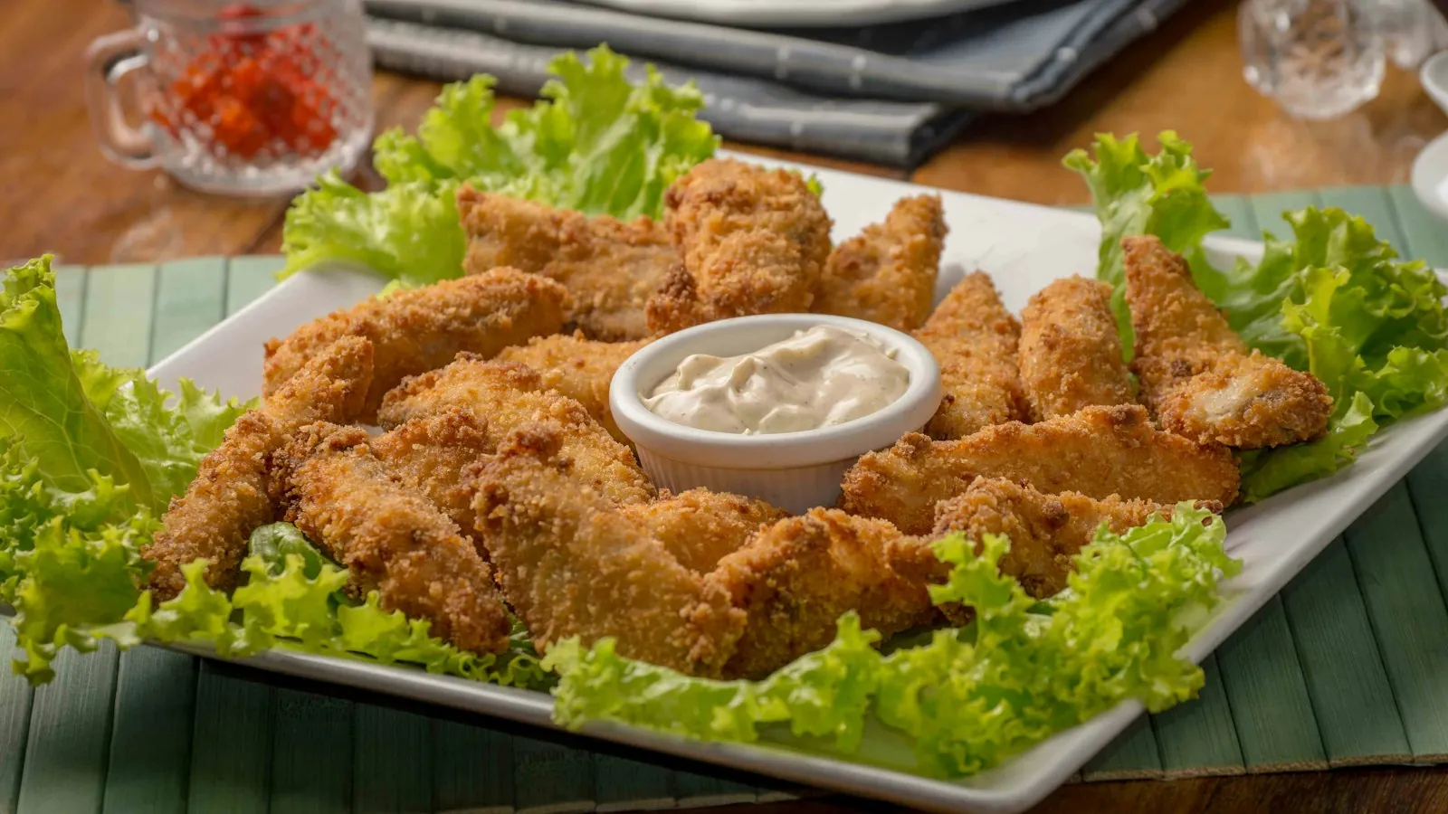 Golden fried chicken pieces with an intact crispy coating and dipping sauce