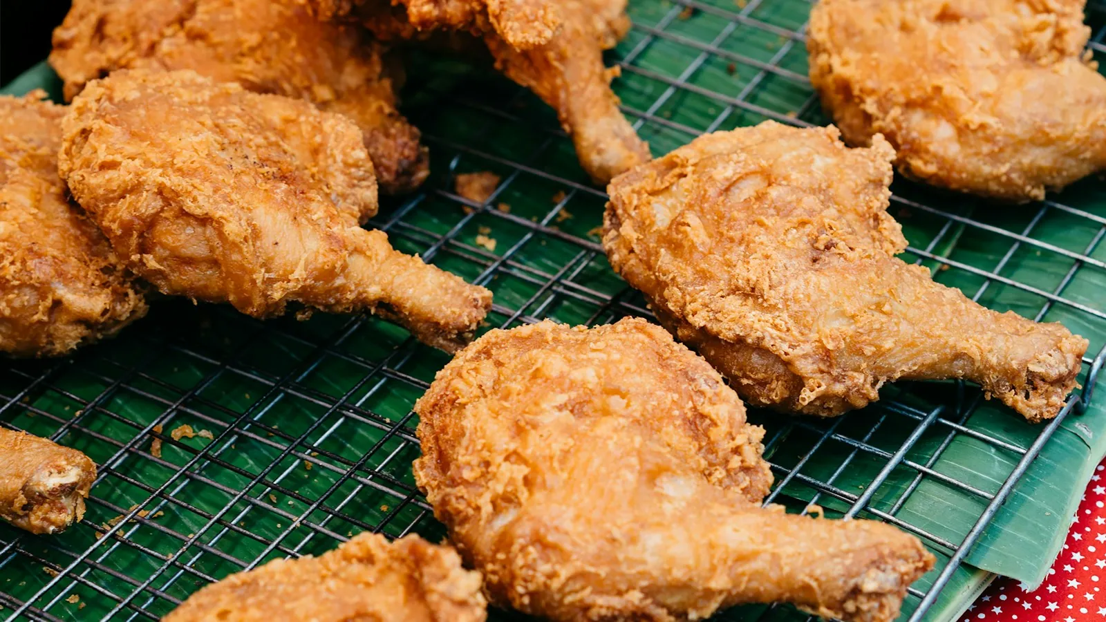 Pieces of fried chicken draining on a wire cooling rack