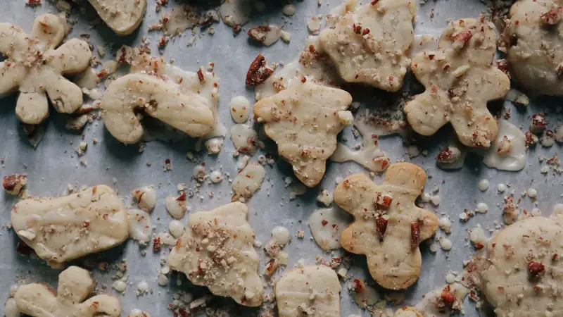Chocolate chip cookies spaced out on a metal baking sheet after baking