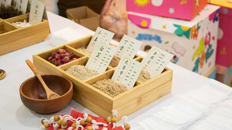 Wooden tray with separate compartments holding different dried herbs and spices