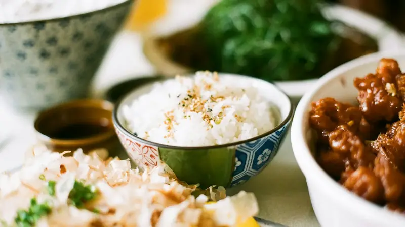 Bowl of steamed white rice in a white and blue ceramic bowl
