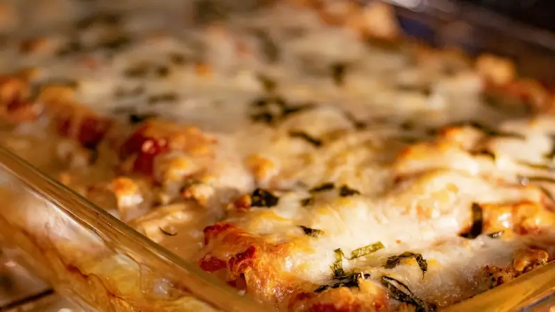 A casserole dish baking on a rack inside a home oven