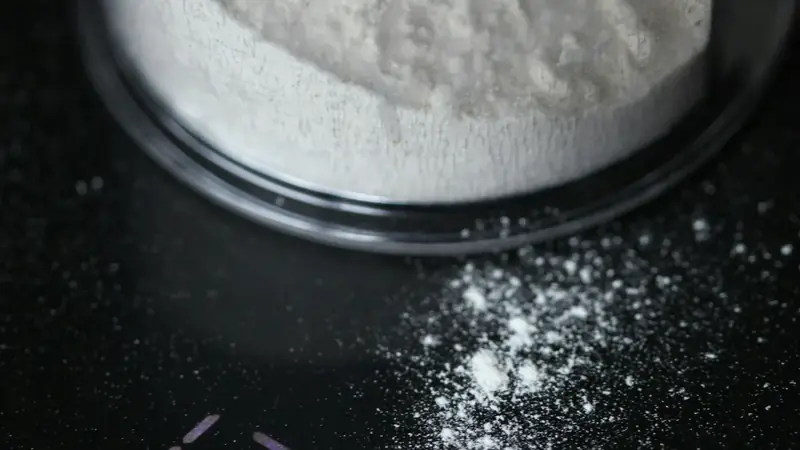 White powder being weighed in a bowl on a digital kitchen scale