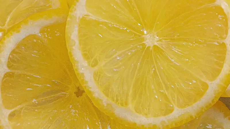 Overlapping slices of bright yellow lemon showing pulp and pale rinds