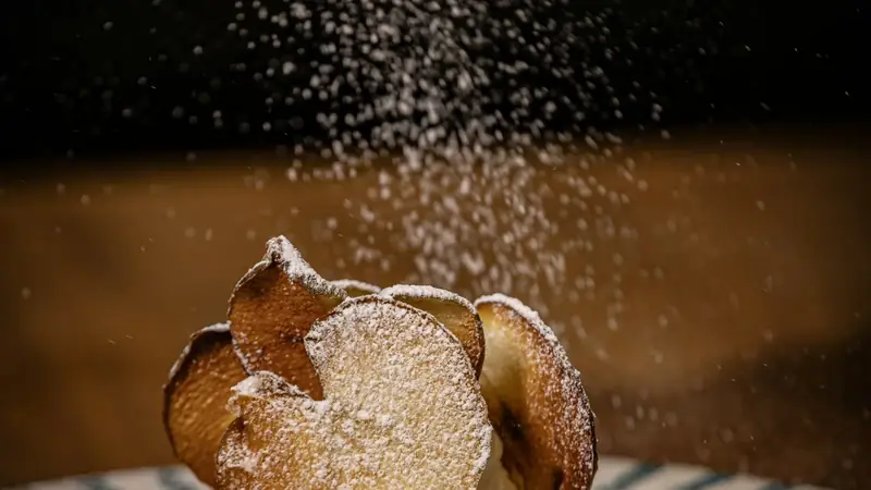 Powdered sugar being sprinkled over a dessert