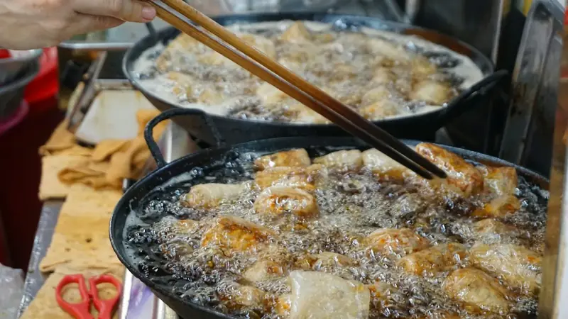 Food frying in a pan of bubbling hot oil on the stove