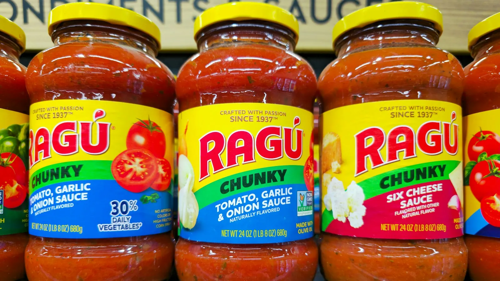 Several jars of chunky tomato pasta sauce lined up on a store shelf
