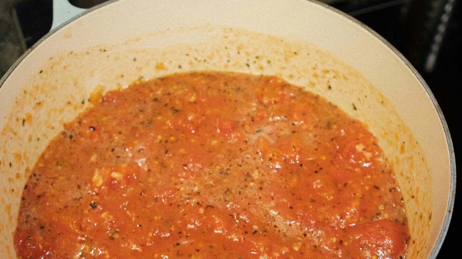 Pot of thick red tomato pasta sauce sitting on a stovetop burner