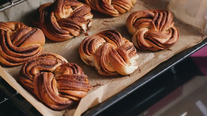A tray of golden pastries baking inside a home oven