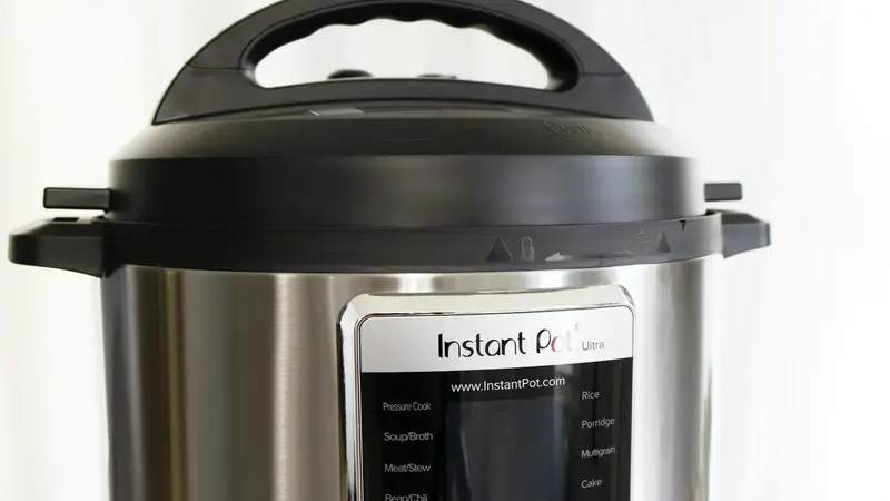 Gray and black electric rice cooker sitting on a kitchen counter