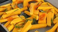Roast butternut squash wedges with browned, caramelized edges spread on a baking tray