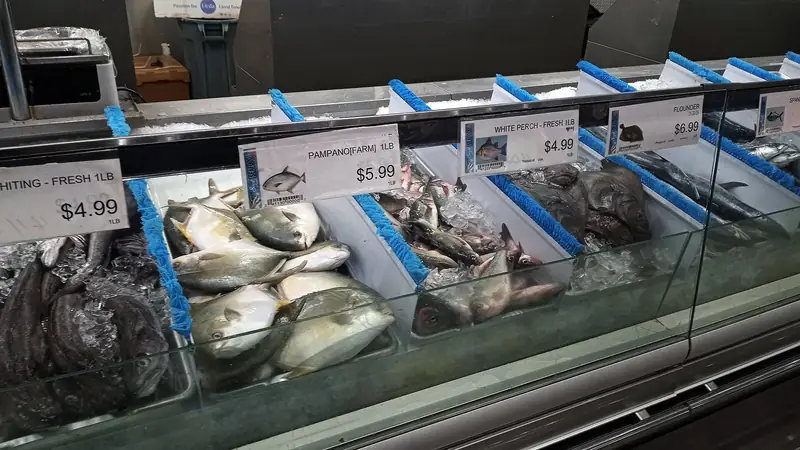 Whole whiting, pompano, white perch and flounder packed in crushed ice in a grocery seafood case