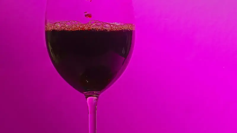Red wine being poured from a bottle into a glass